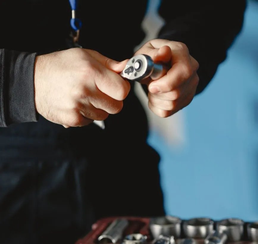 Hands fitting a socket to a ratchet over an open case of sockets